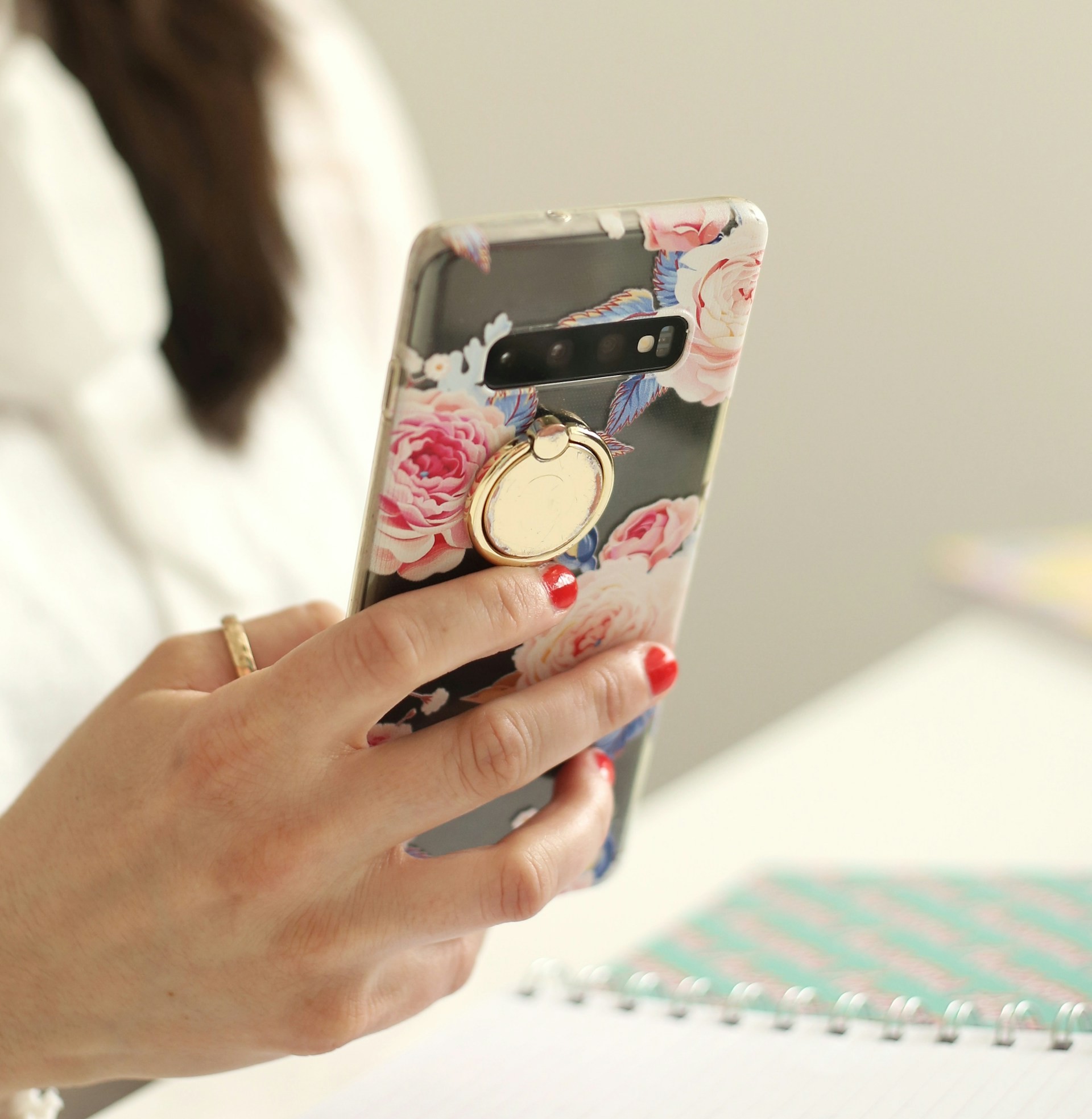 スマホリングの付いた携帯を使用中の女性