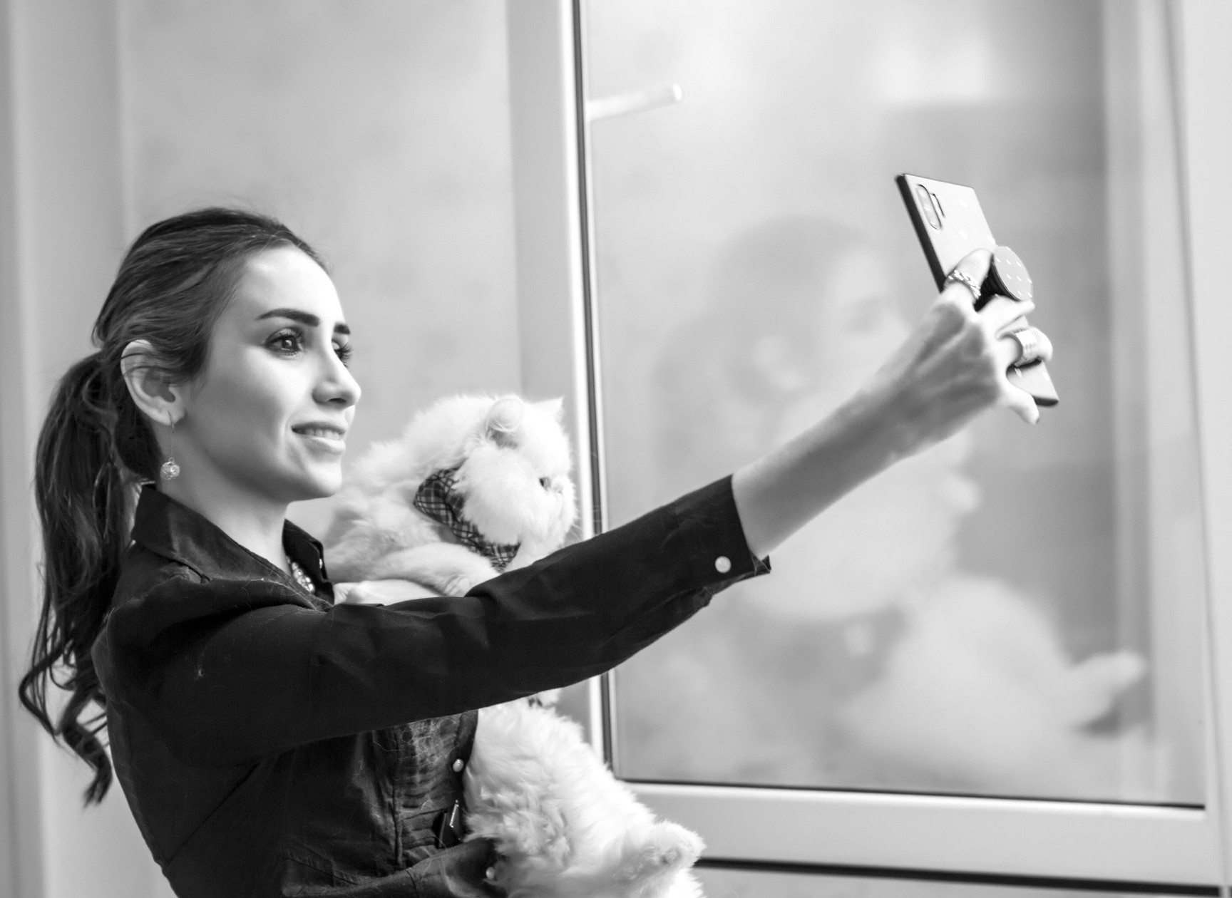 スマホリングを使って犬と自撮りをする女性