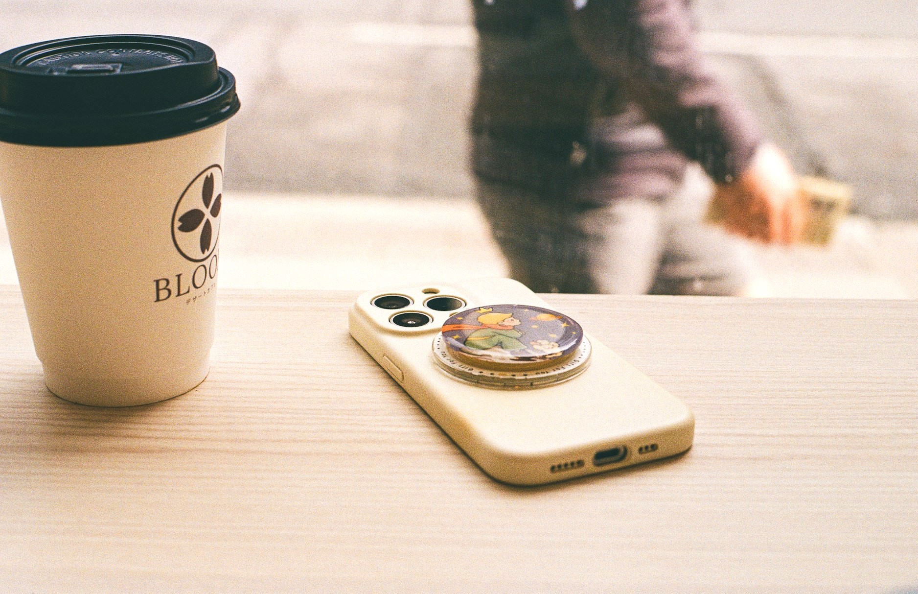 カフェのテーブルの上に置かれたスマホリングの付いたスマホ