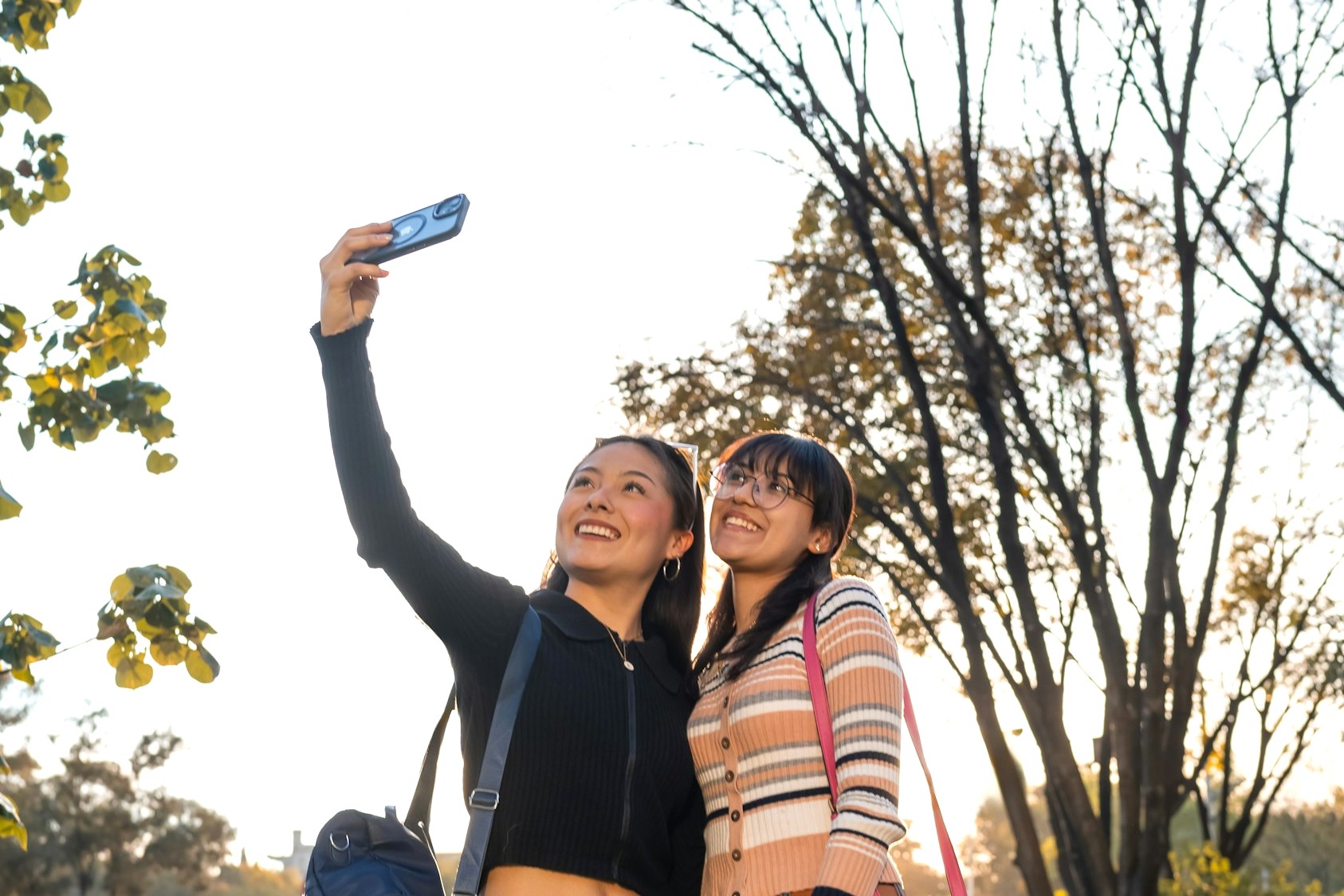 スマホリングを使って片手で自撮りする二人の女性