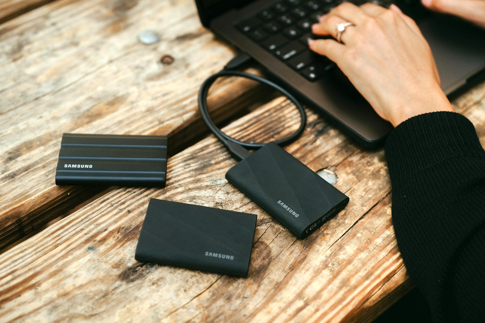 屋外でPCにモバイルバッテリーを繋げて充電している様子