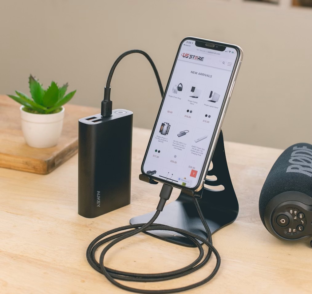 机の上でスマホスタンドに置いたスマホを充電する様子