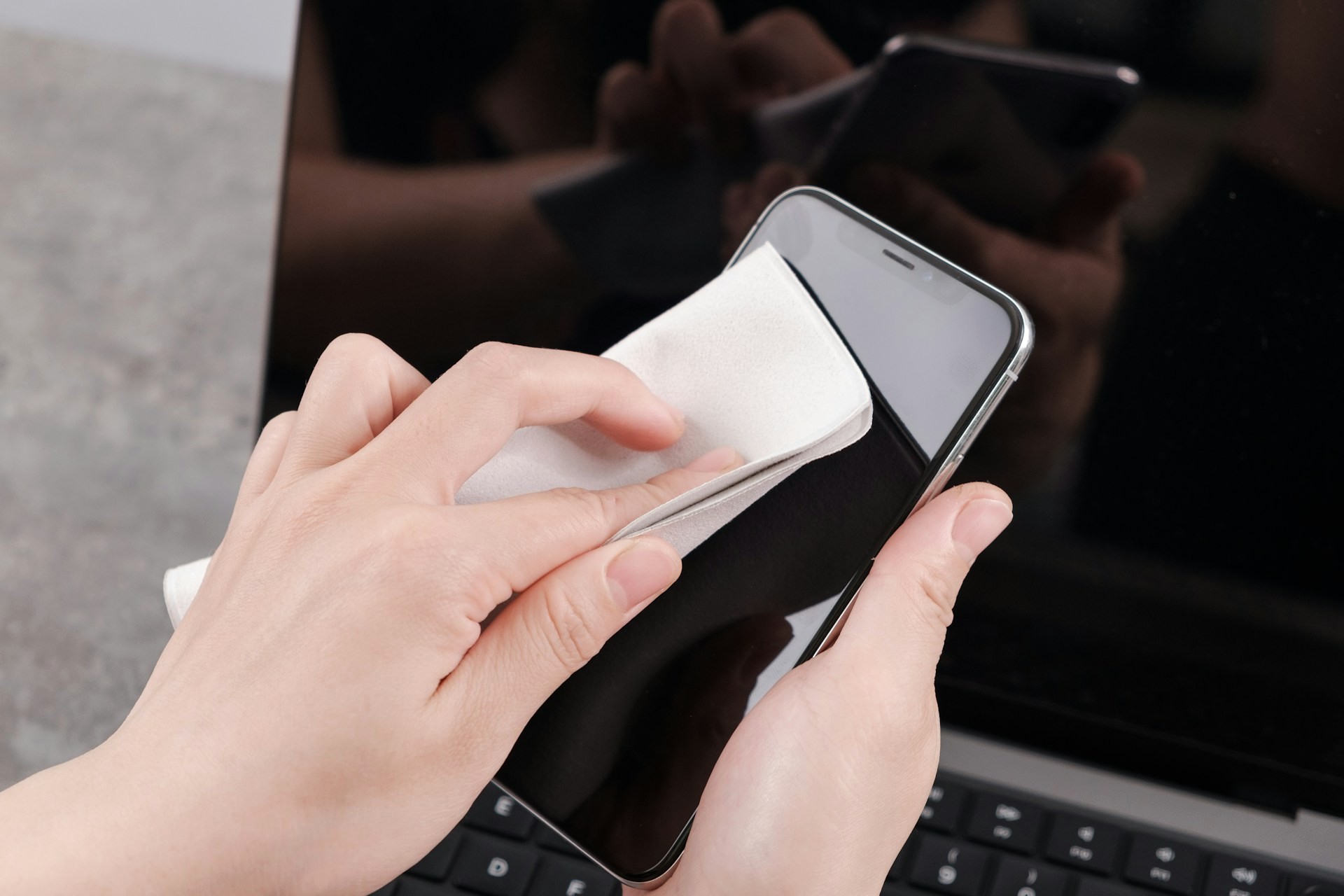 スマホをクリーニングクロスで拭いている様子