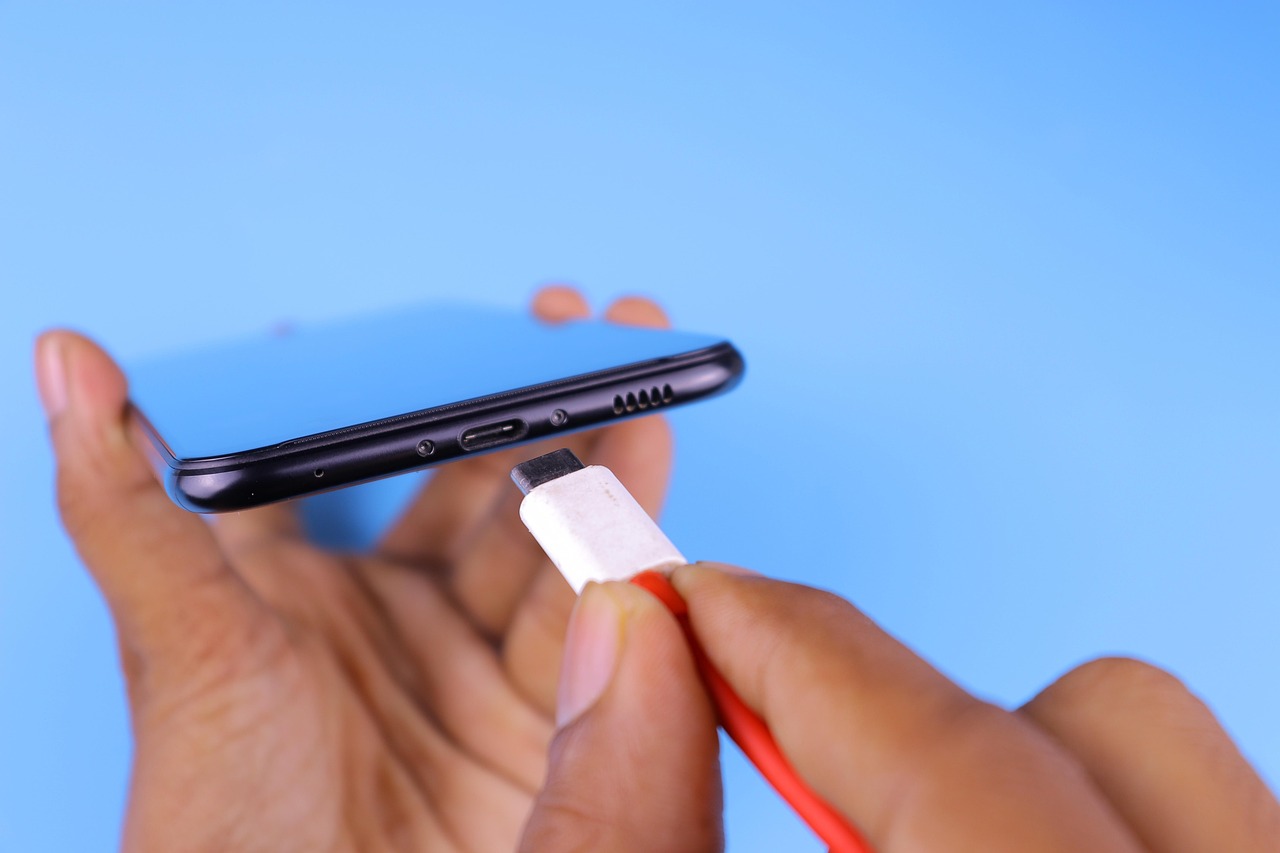 スマホに充電ケーブルを挿しこむ様子